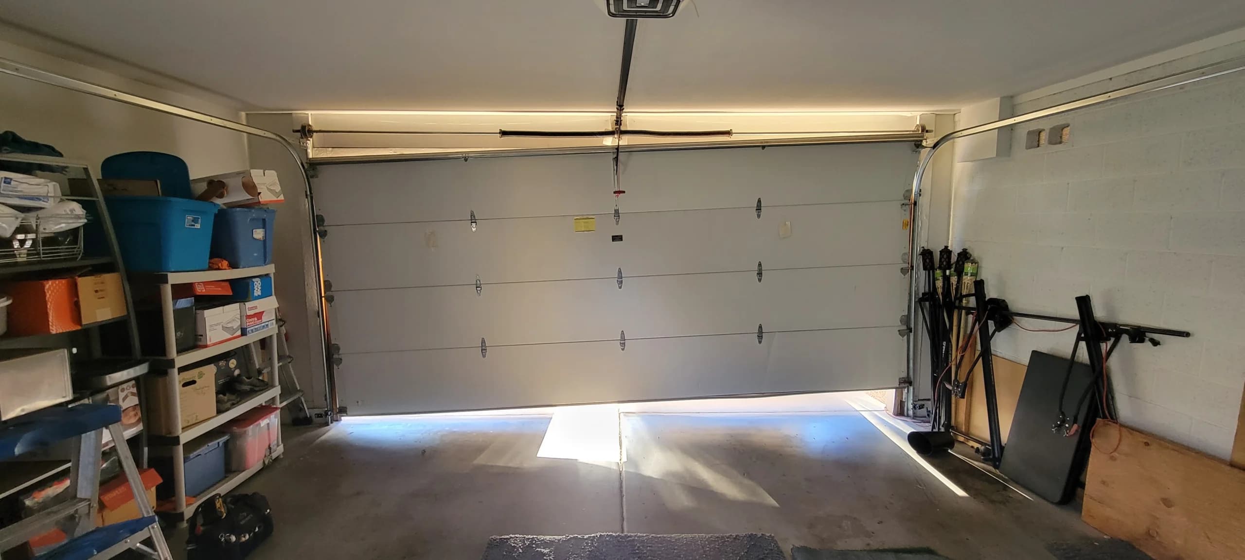 A crooked, off-track garage door requiring emergency garage door repair inside a home garage.