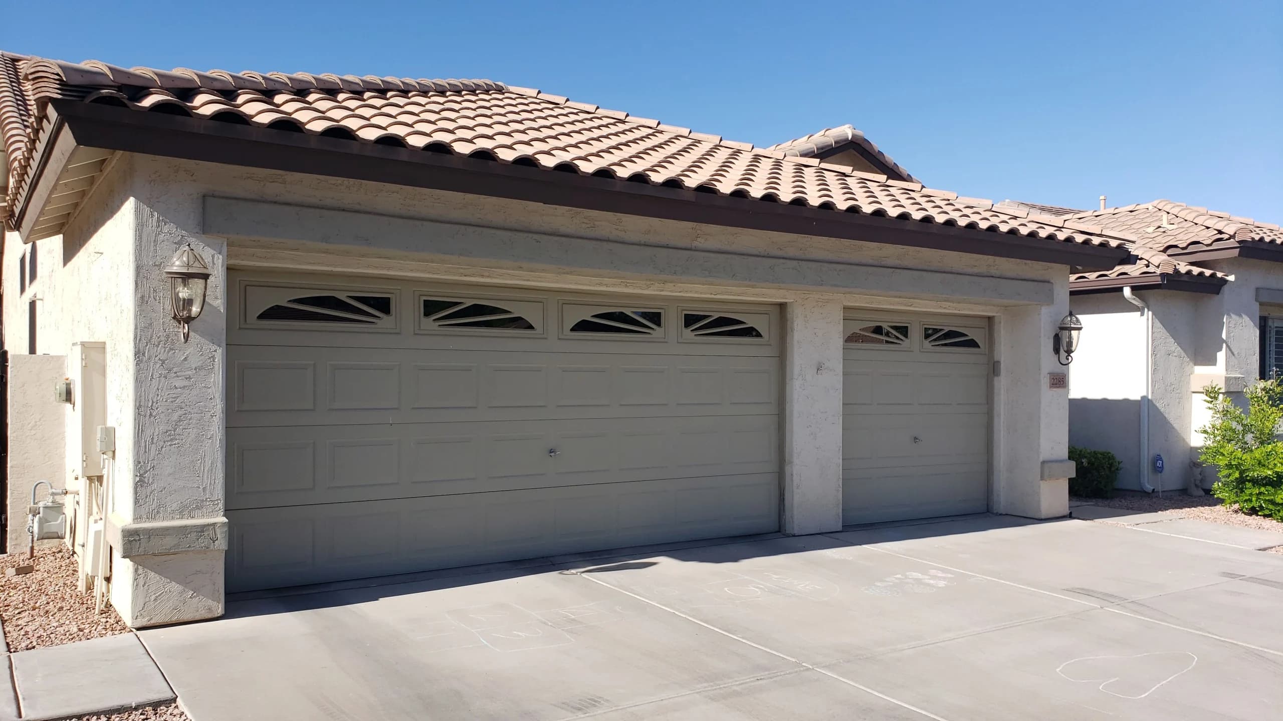 Traditional raised-panel garage doors requiring a garage door replacement in Chandler, AZ