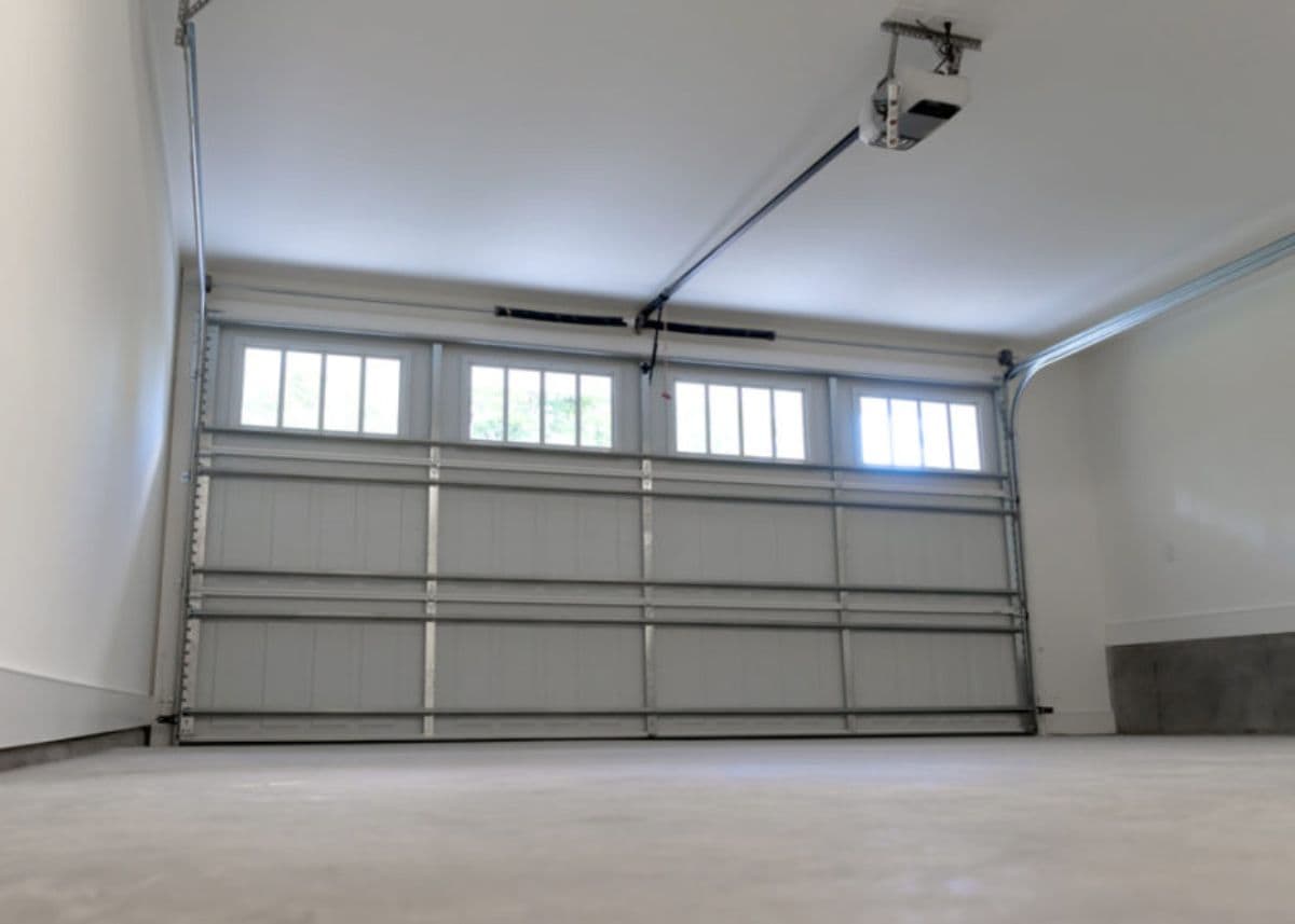 Garage interior with a windowed door and ceiling-mounted opener