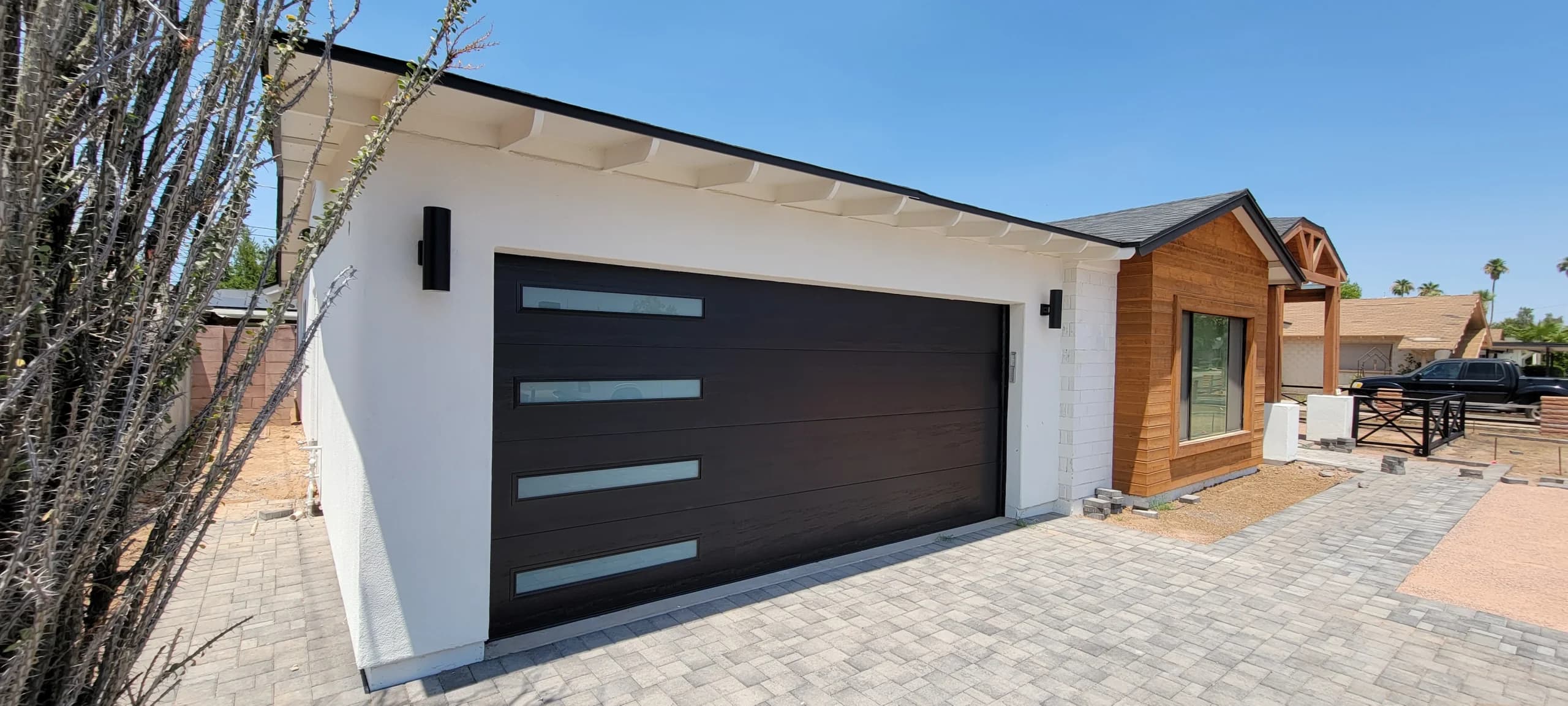 A modern black new garage door with stacked horizontal frosted windows