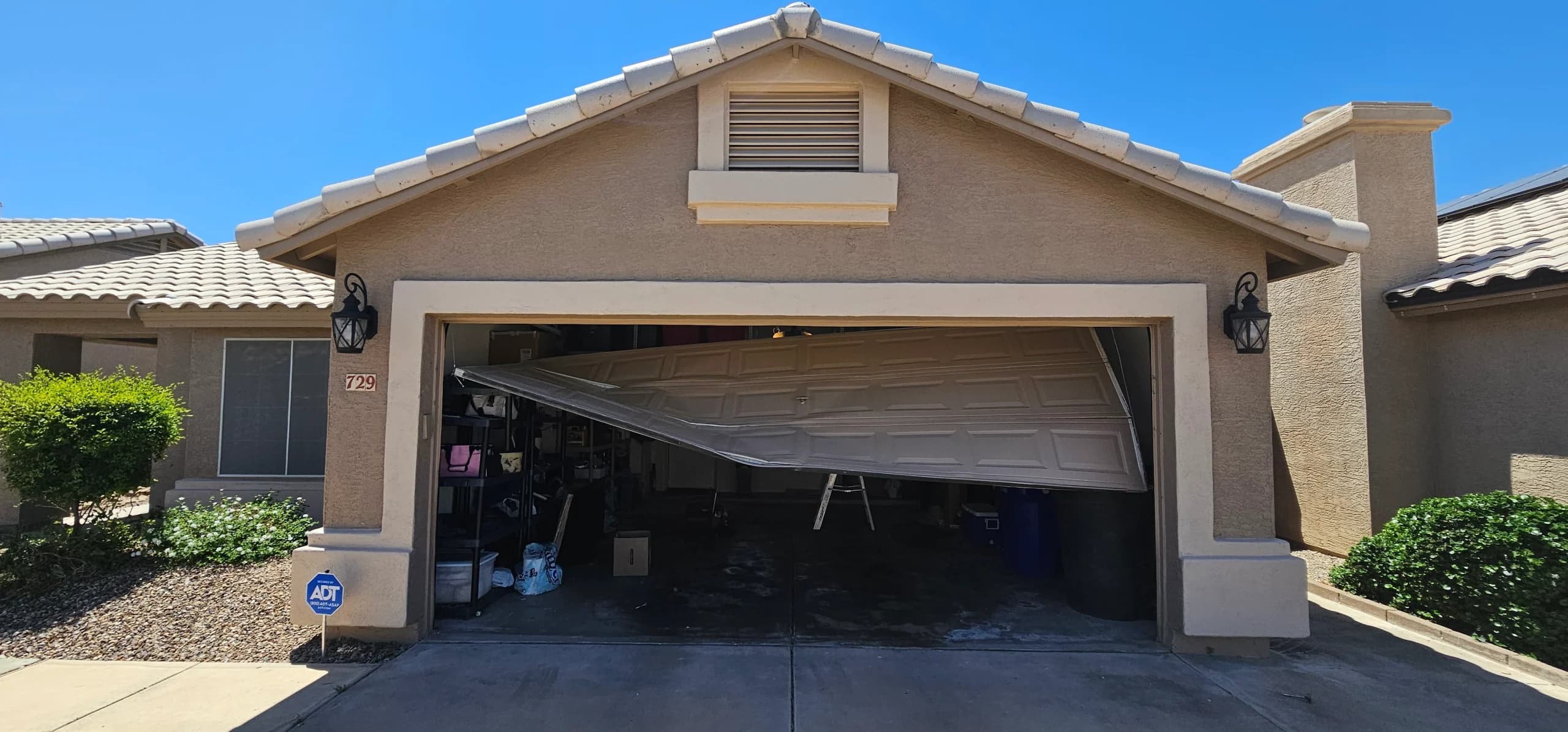 A severely buckled and damaged door showcasing the poor overall condition of the garage door system.
