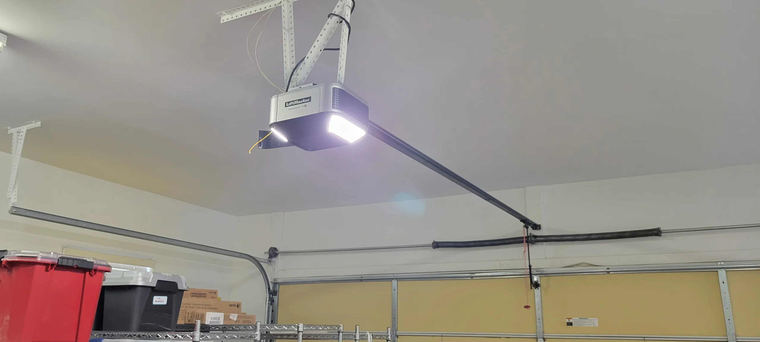 An illuminated ceiling unit indicating the cause of LiftMaster beeping alerts in a garage.