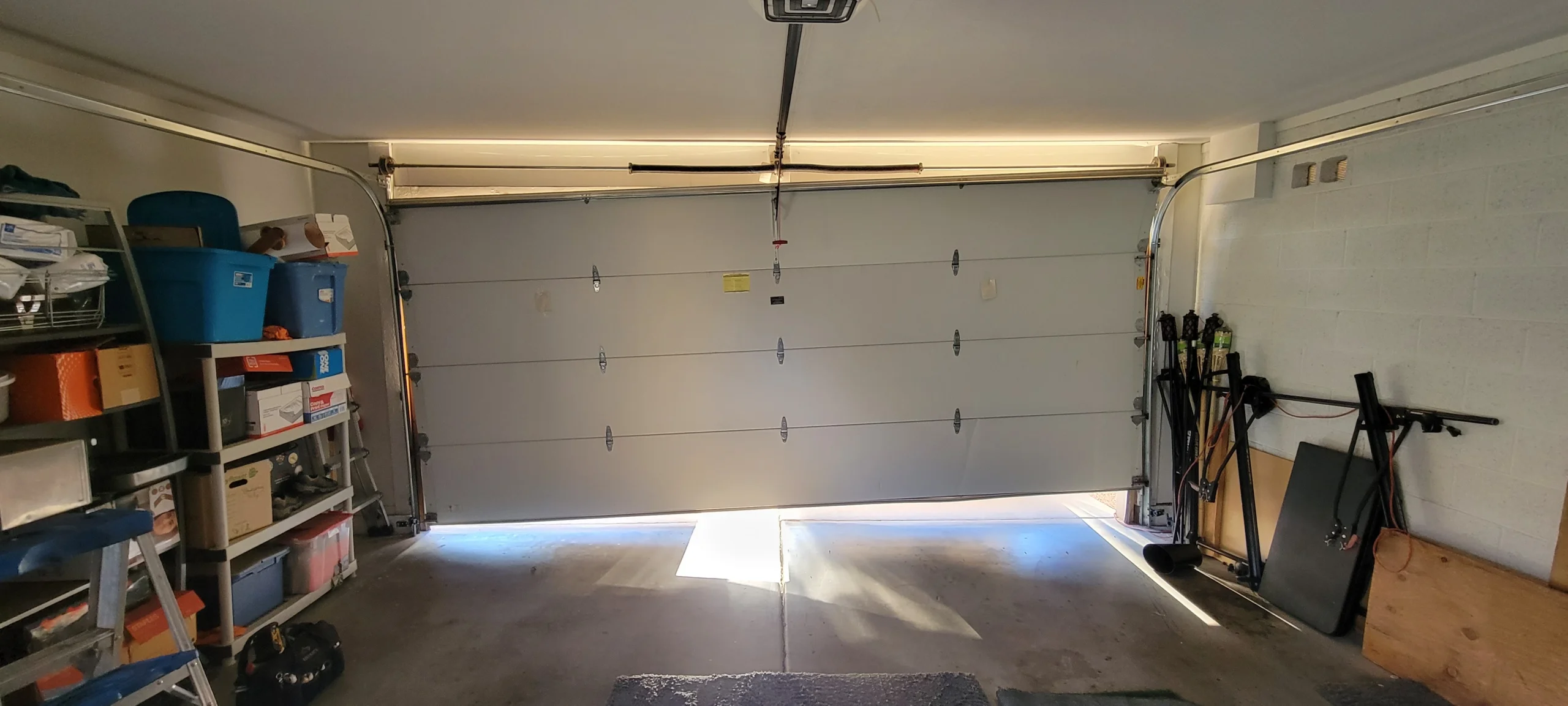 A crooked, off-track garage door requiring emergency garage door repair inside a home garage.