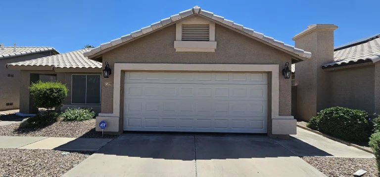 A standard sectional white garage door on a residential home setup for a new garage door near me