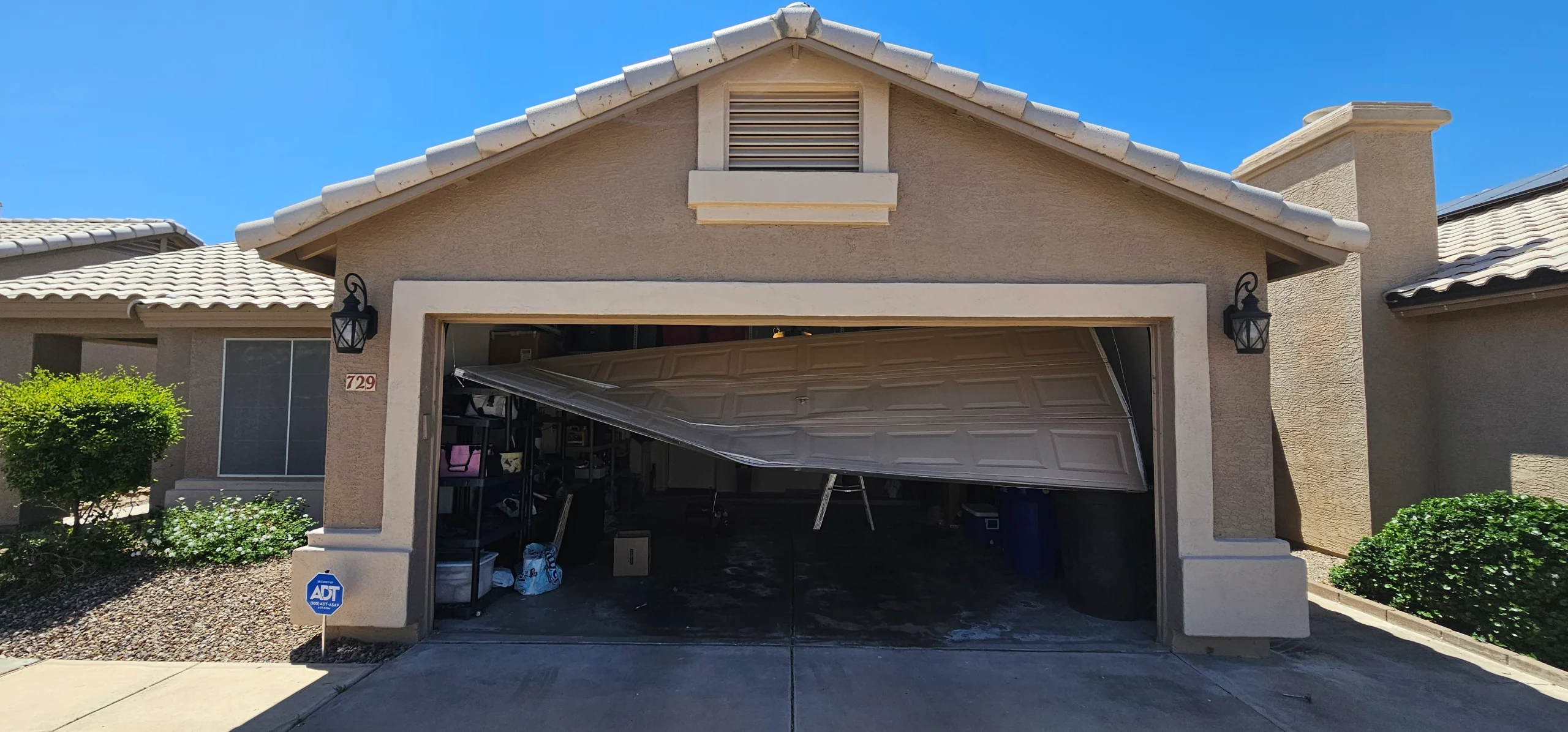 A severely buckled and damaged door showcasing the poor overall condition of the garage door system.